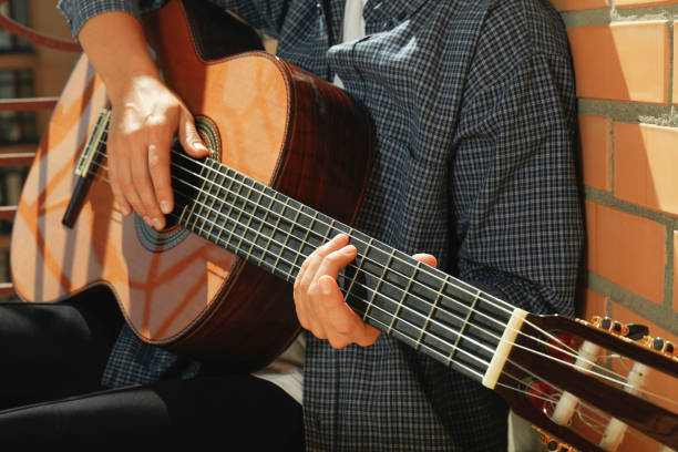 istock Woman in shirt playing on classical guitar 1490321944
