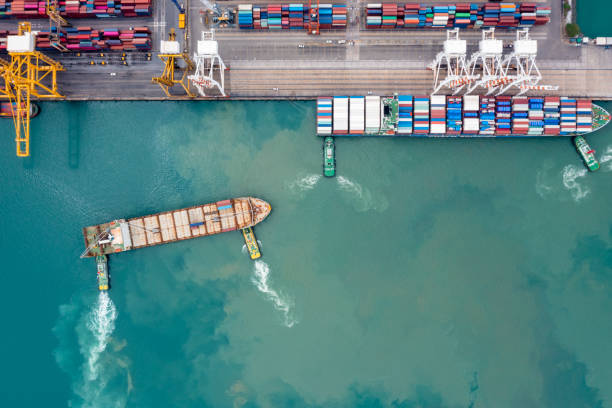 istock container ship and tug boat to quayside for load and unload container via crane for logistics, import export goods internationally around the world, including Asia Pacific and Europe 1490323175