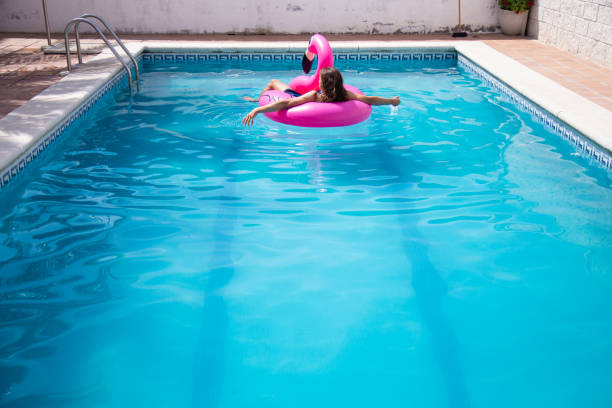 Girl swimming in the pool with the help of a rubber ring