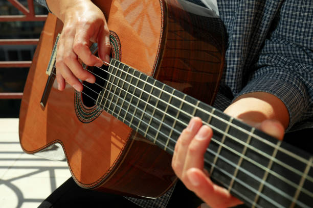 istock Woman in shirt playing on classical guitar 1490323709