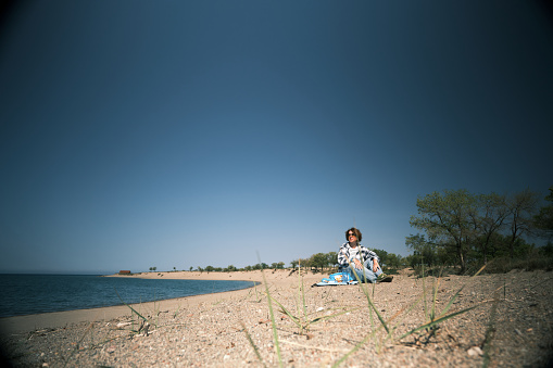 Woman is having a rest on the mountain lake