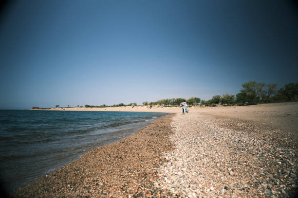 istock Woman is walking on the water's edge 1490325960