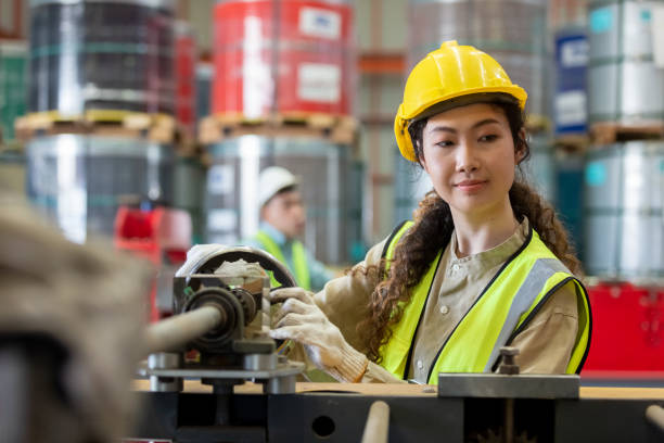 istock woman engineer wear hard hat working at machine in factory. female technician control metalwork lathe industrial. female workshop technology manufacturing. 1490326010