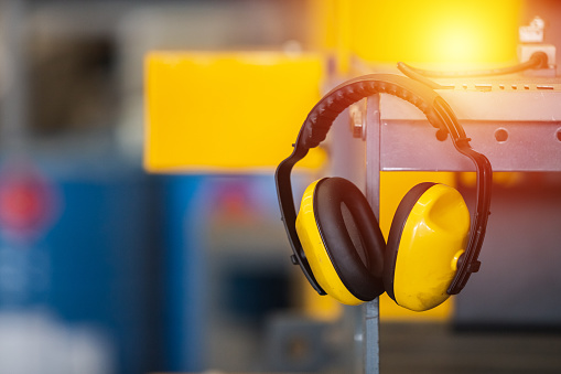 Soundproof headphones for industry plants hanging on lathe in factory. headphones protection equipment for use in industrial work. protection equipment ear safety.