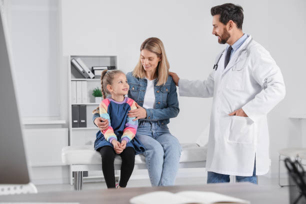 happy mother and daughter having appointment with doctor. pediatrician consulting patient in clinic - primary care imagens e fotografias de stock