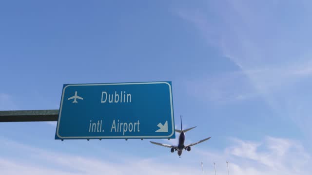 airplane passing over dublin airport sign