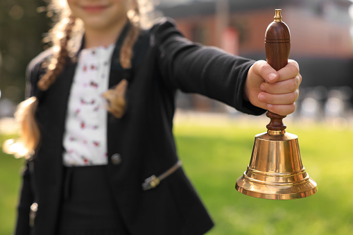 A hand holding a bell in a school