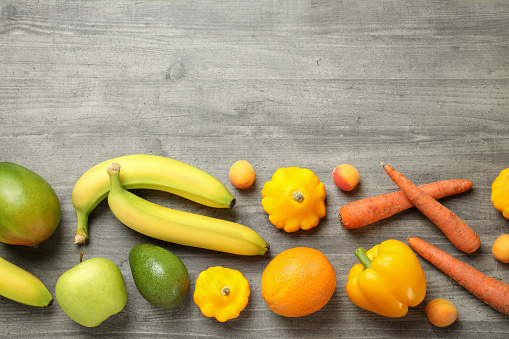 Set of different vegetables and fruits on gray textured background