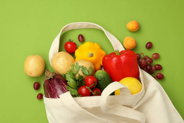 istock Cotton bag with vegetables and fruits on green background 1490335321