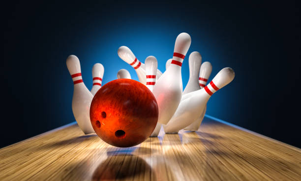 istock bowling ball hits pins falling on the track 1490337723