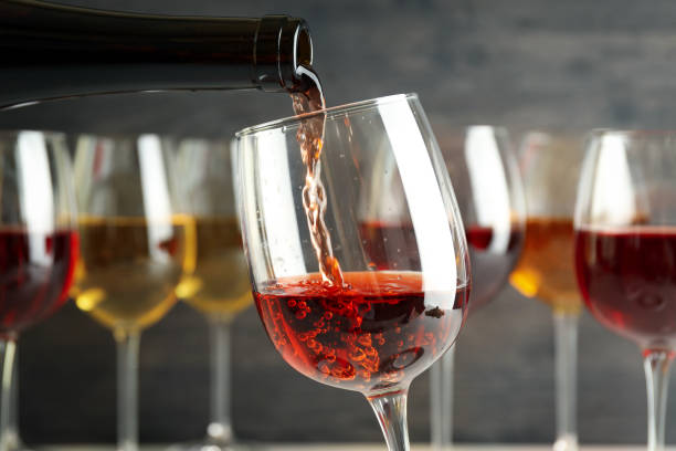 istock Wine is poured from bottle into a glass, close up and selective focus 1490337812