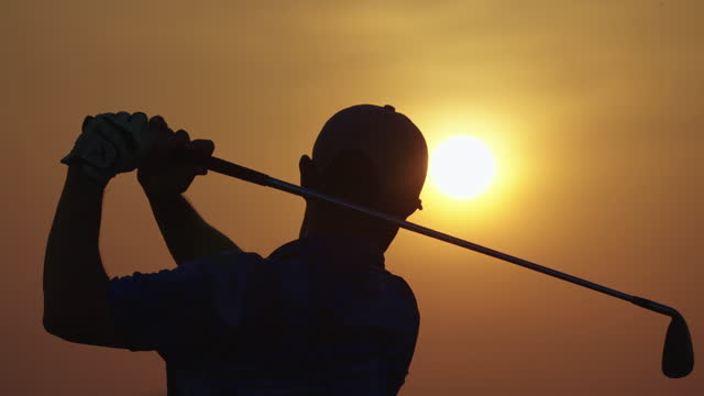 Male golfer teeing off on fairway at sunset ,layout beauty and player exercise to good health.