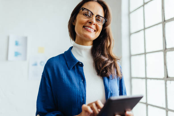 istock Creative business woman smiling and using a tablet in an office 1490342971