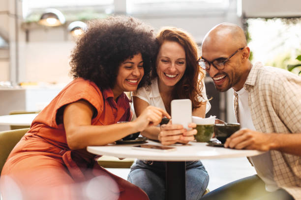 istock Three happy friends browsing social media on a smartphone during their coffee break 1490343984