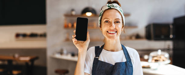 istock Successful small business owner recommending a smartphone for restaurant management 1490344099