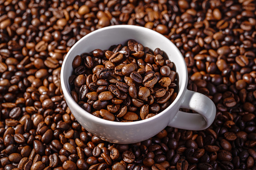 Roasted coffee beans with a cup