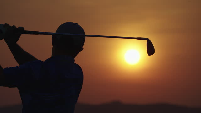 Male golfer teeing off on fairway at sunset ,layout beauty and player exercise to good health.
