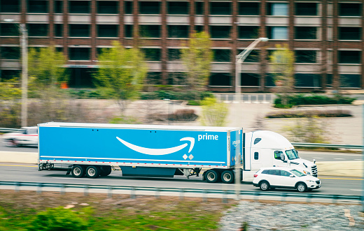Nashville, USA - Side view of a large Amazon Prime delivery truck, with motion blur on the background as it passes on Interstate 40 at speed.