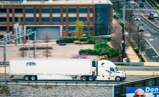Nashville, USA - A large Fox Express delivery truck on the highway, passing buildings and traffic on I40 on the east side of Nashville.