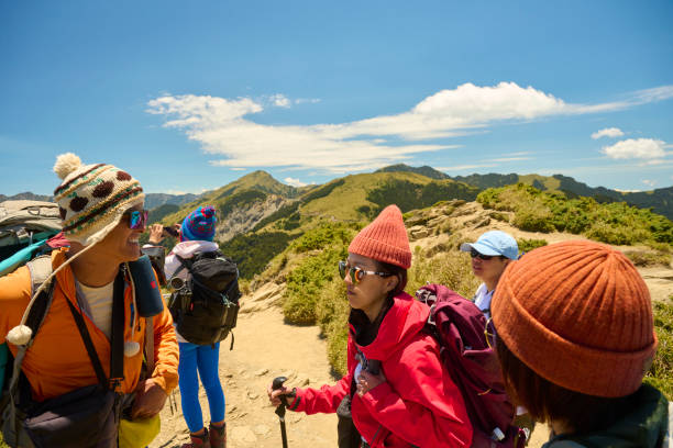 istock Hikers stand on top of a mountain looking at view. 1490352759