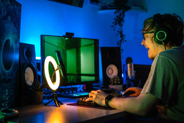 istock A man playing online game in blue lit room. 1490353424