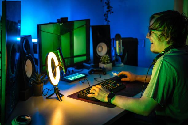 istock Gamer playing video games online while broadcasting in blue lit room. 1490353426