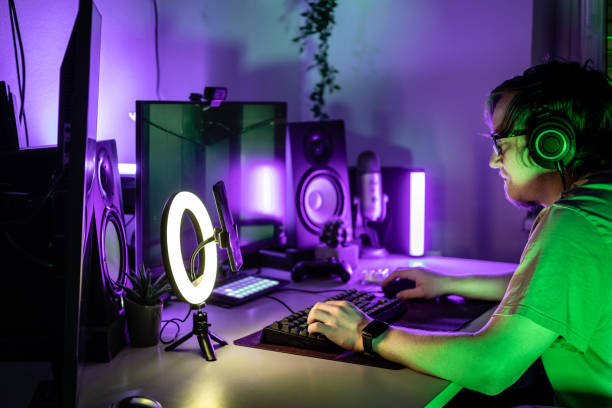 istock A man playing online game in purple lit room. 1490353474