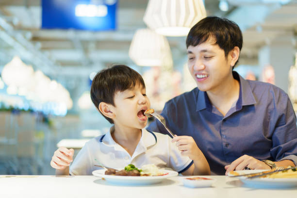 istock Dad and son eating in restaurant. 1490357103