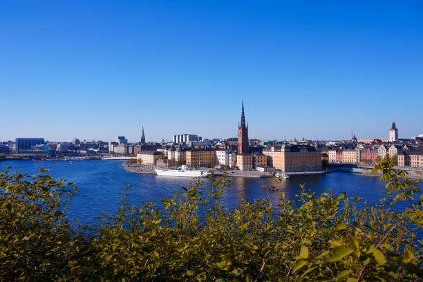 istock View of buildings by river against blue sky 1490357878
