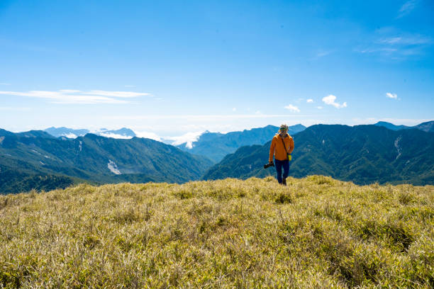 Hikers stand on top of a mountain looking at view.