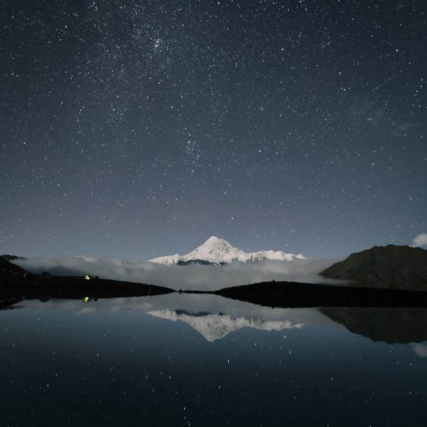 istock a lake with a mountain in the background under stars and clouds 1490358485