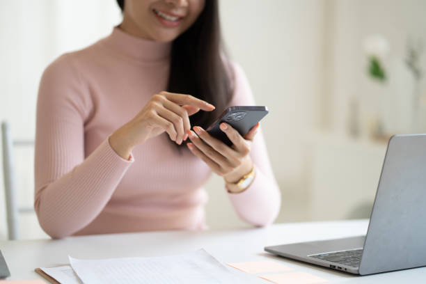 istock Close up view of young female using smartphone while sitting in a comfortable room. 1490358531