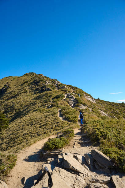 Hikers walking alone on top of a mountain.