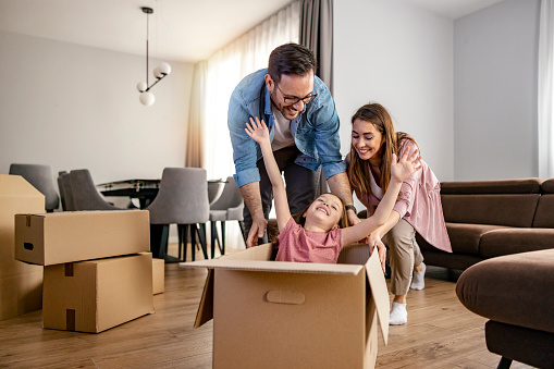 Concept of starting a new life for a happy family. Happy family with cardboard boxes.