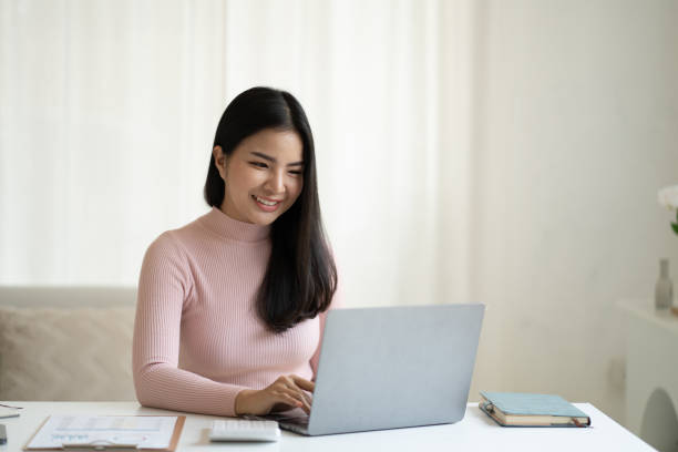istock Portrait of beautiful Asian business woman working on her project while using laptop computer. 1490362086