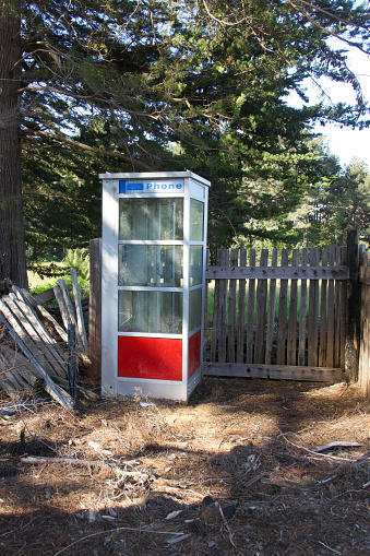 Abandoned pay telephone booth found on an empty lot