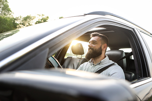 Mid adult businessman driving a car. About 30 years old, Caucasian male.