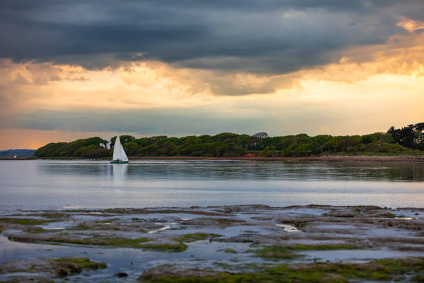 Sunset over a sailing boat moored at Instow on the north coast of Devon