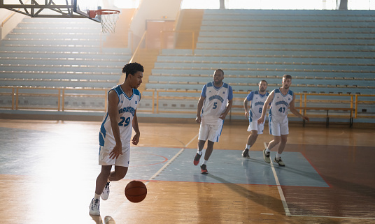Professional male basketball players having training on indoor court. Team sport and healthy lifestyle concept.