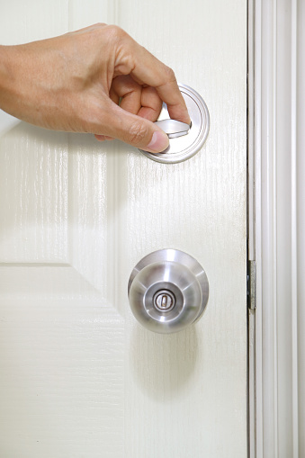 Person closing the door with deadbolt lock