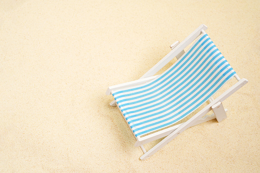 Vacation, beach, travel, relaxation concept. background with blue beach chair on the sand. Minimalism with copy space