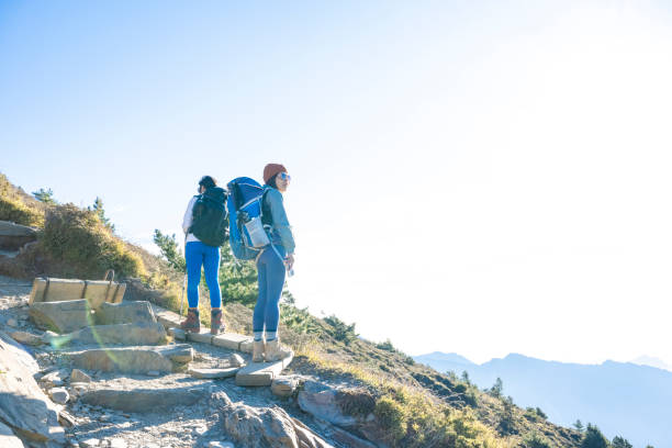 Hikers stand on top of a mountain looking at view.