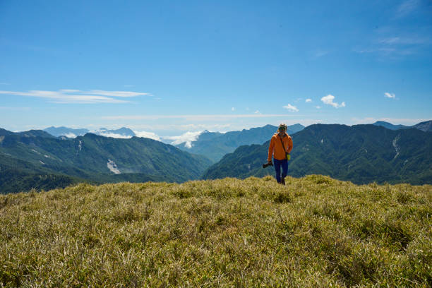 Hikers stand on top of a mountain looking at view.