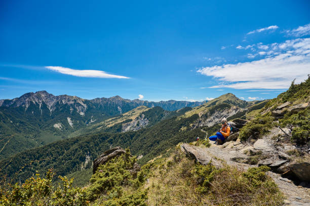 Hikers stand on top of a mountain looking at view.