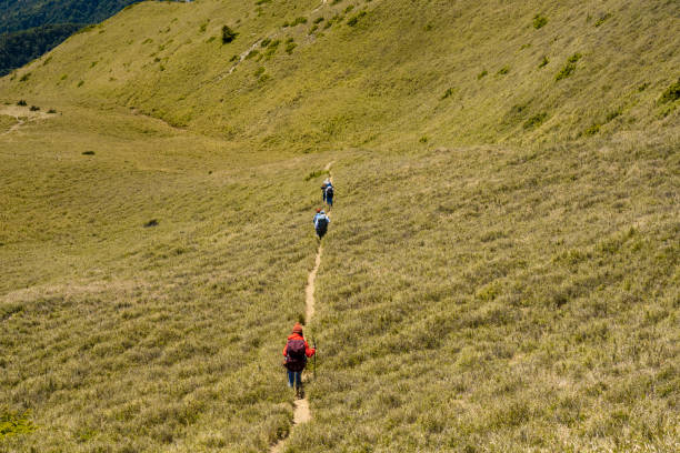 Hikers walking alone on top of a mountain.