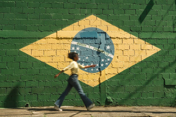 Brazil a woman walks in front of the brazil flag painted on a wall santana photos stock pictures, royalty-free photos & images