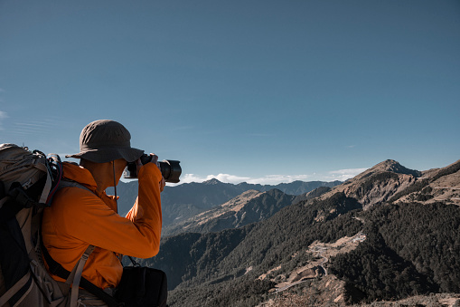 Mountain hiker taking photos on the mountain top.