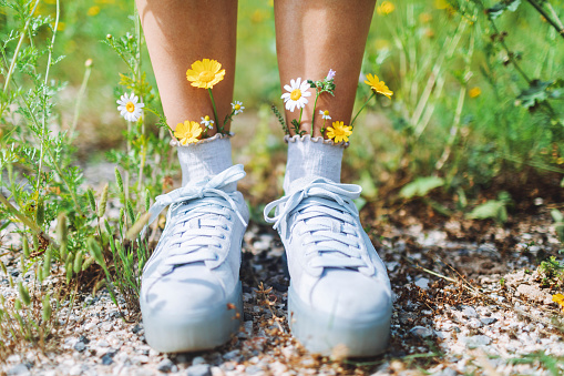 Blossom-decorated socks and sneakers on women's feet