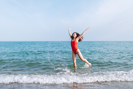 Young woman in a red swimsuit at the seaside