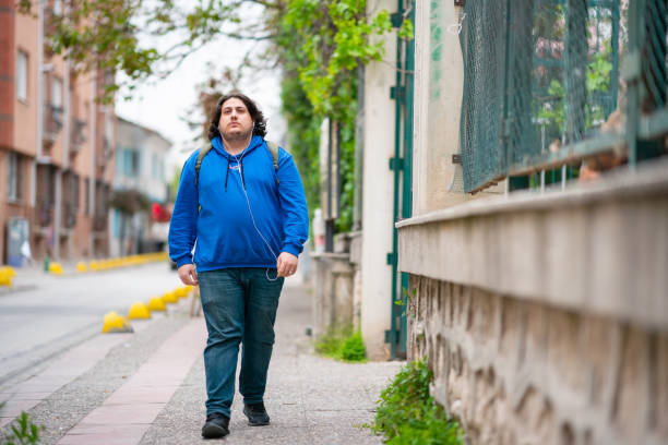 Full figured young man walking in the city with backpack